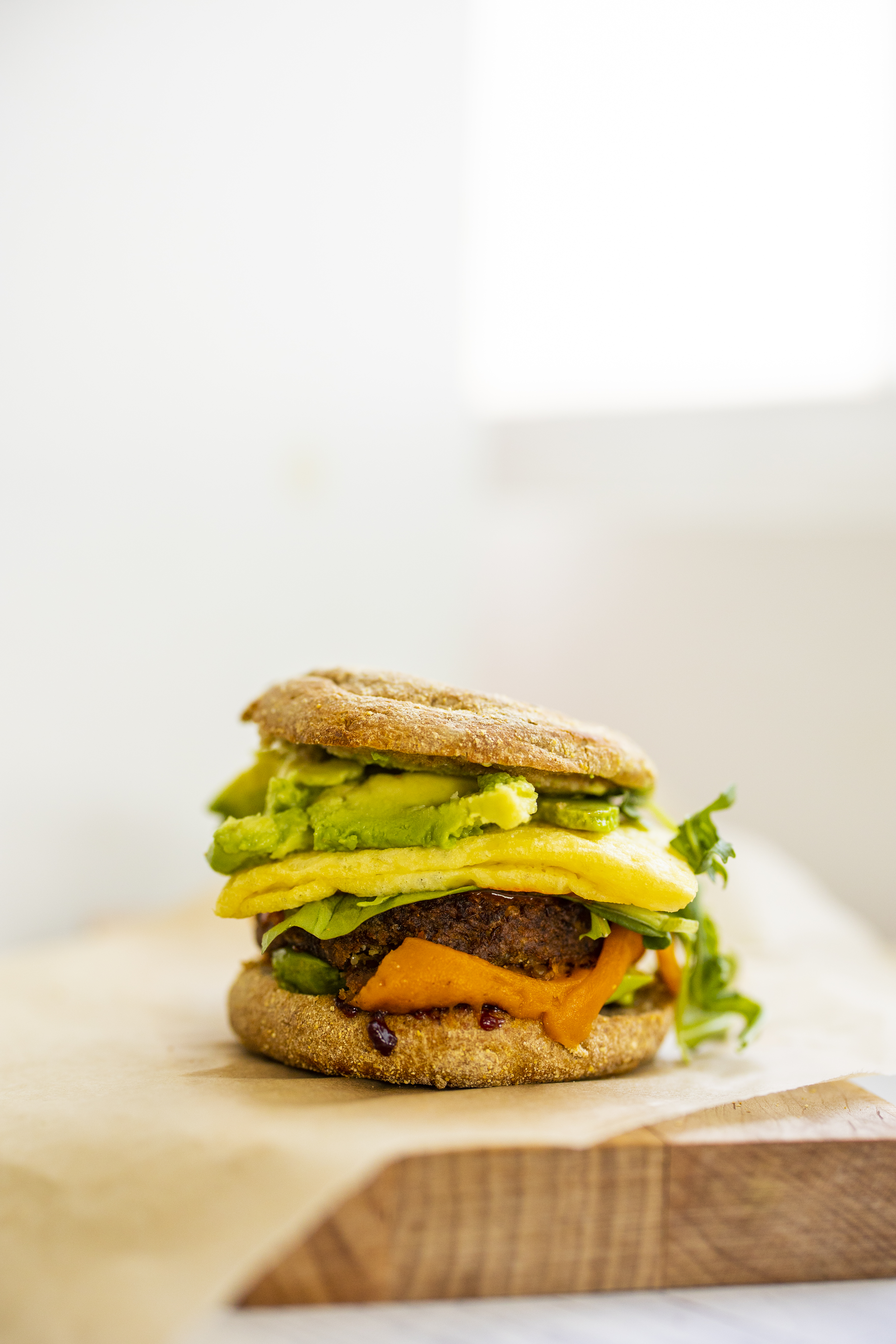 hearty vegan breakfast sandwich with avocado, sausage and 'egg'