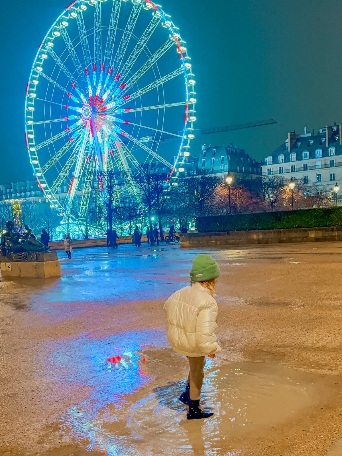 night puddle at Christmas market near Louvre ferris wheel lit up